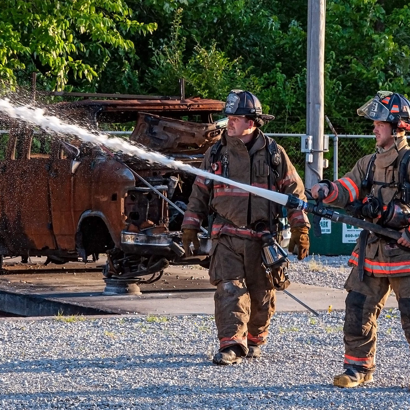 Fireman and trainer with fire hose preparing for a training exercise.