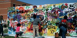 Students writing on the graffiti wall. Financial Aid Programs Affected by SAP