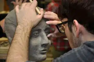 Artist sculps human head out of clay