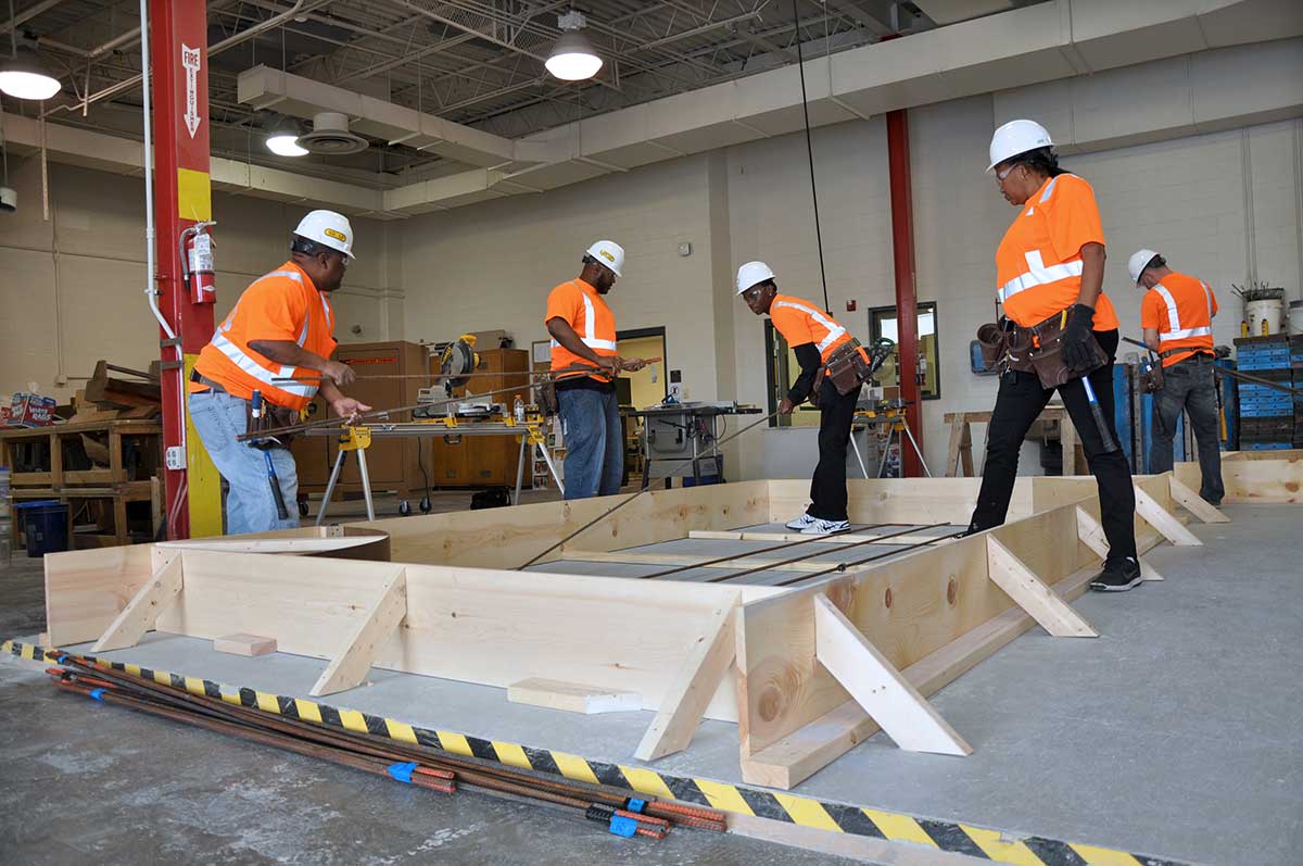 Students in construction apprenticeship training completing work