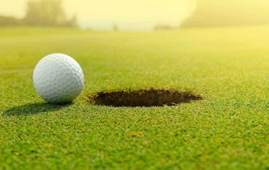 Close up of a golf ball close to the hole