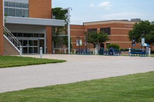 Photo of an African American male sitting in front of the Liberal Arts building.