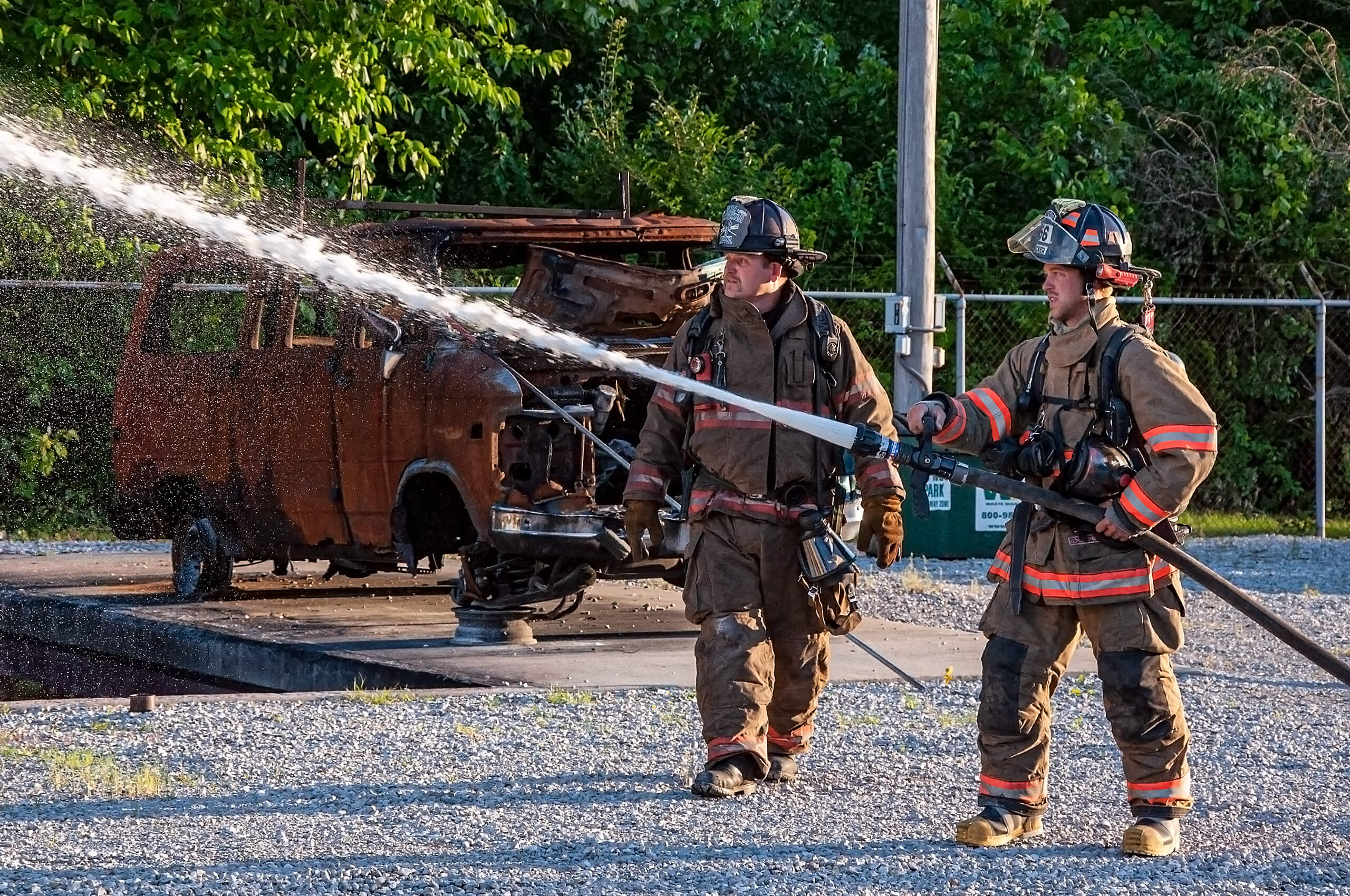 Fireman and trainer with fire hose preparing for a training exercise.