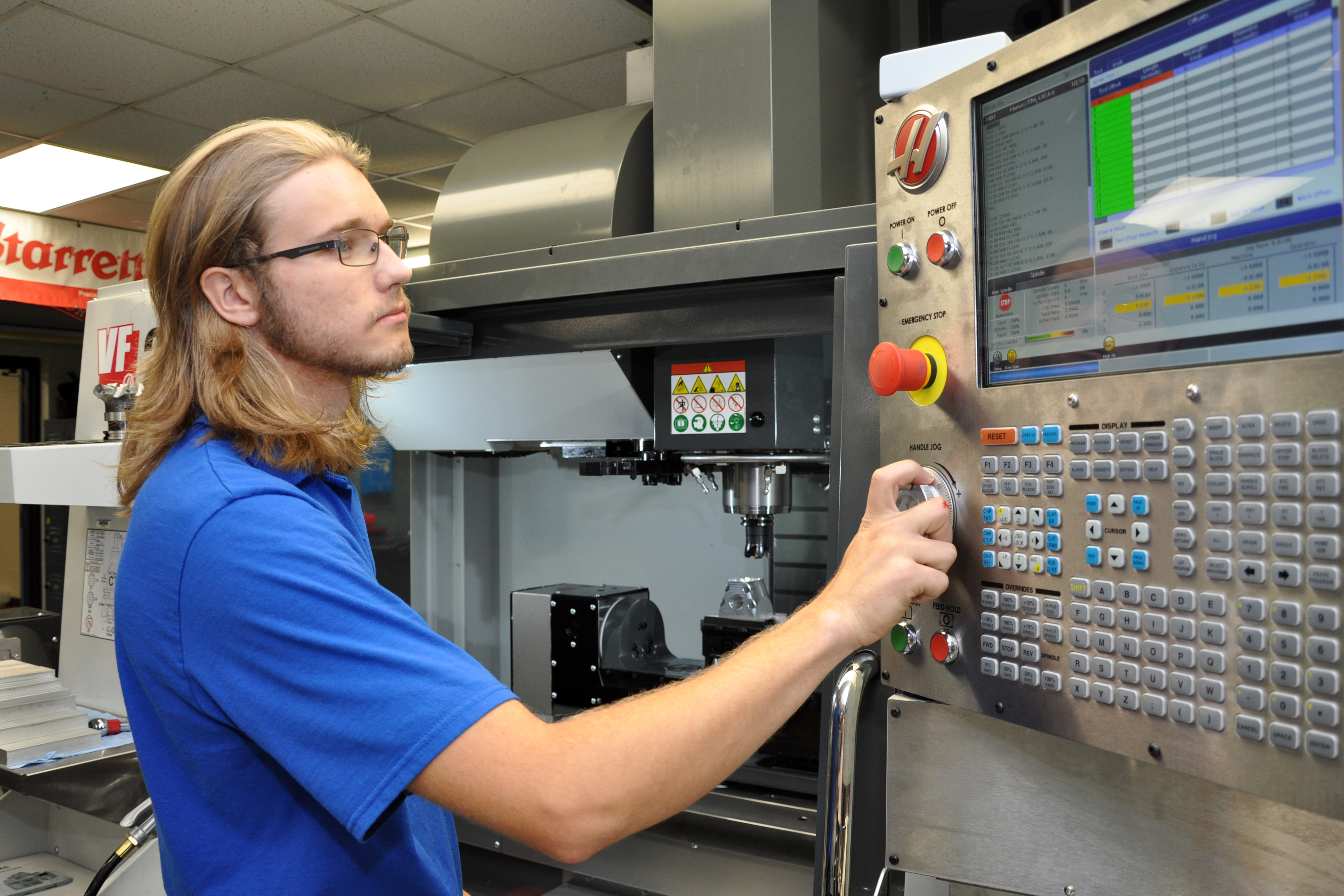 Precision Machining Technology student programming a CNC lathe.