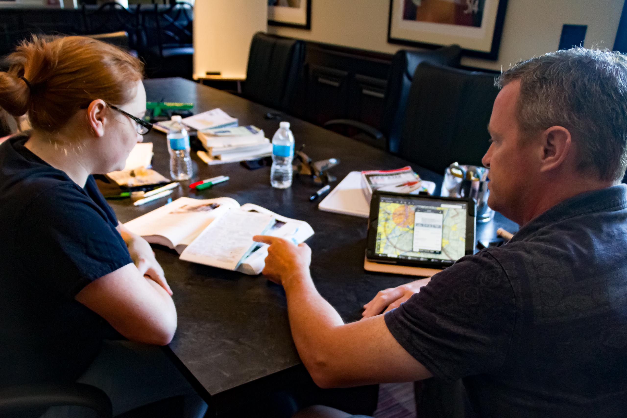 Instructor teaching pilot training to student.