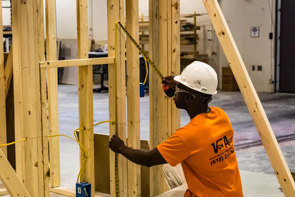 Student measuring stud in construction carpentry.