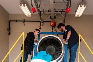Aircraft Maintenance students working on engine.