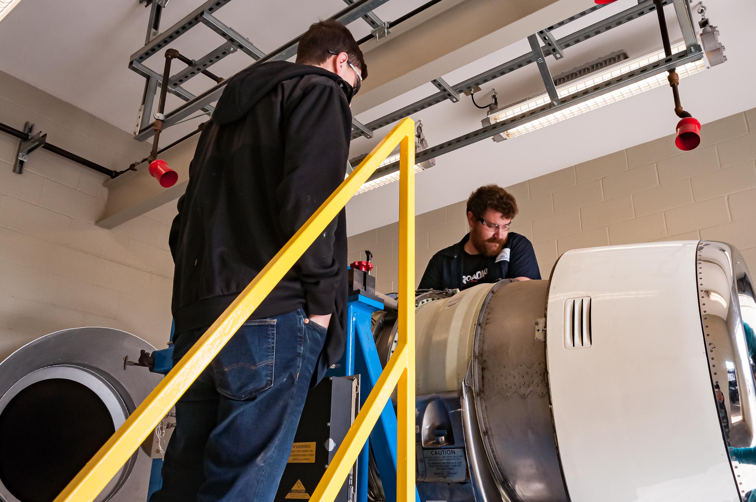 Aircraft Maintenance students working on engine.