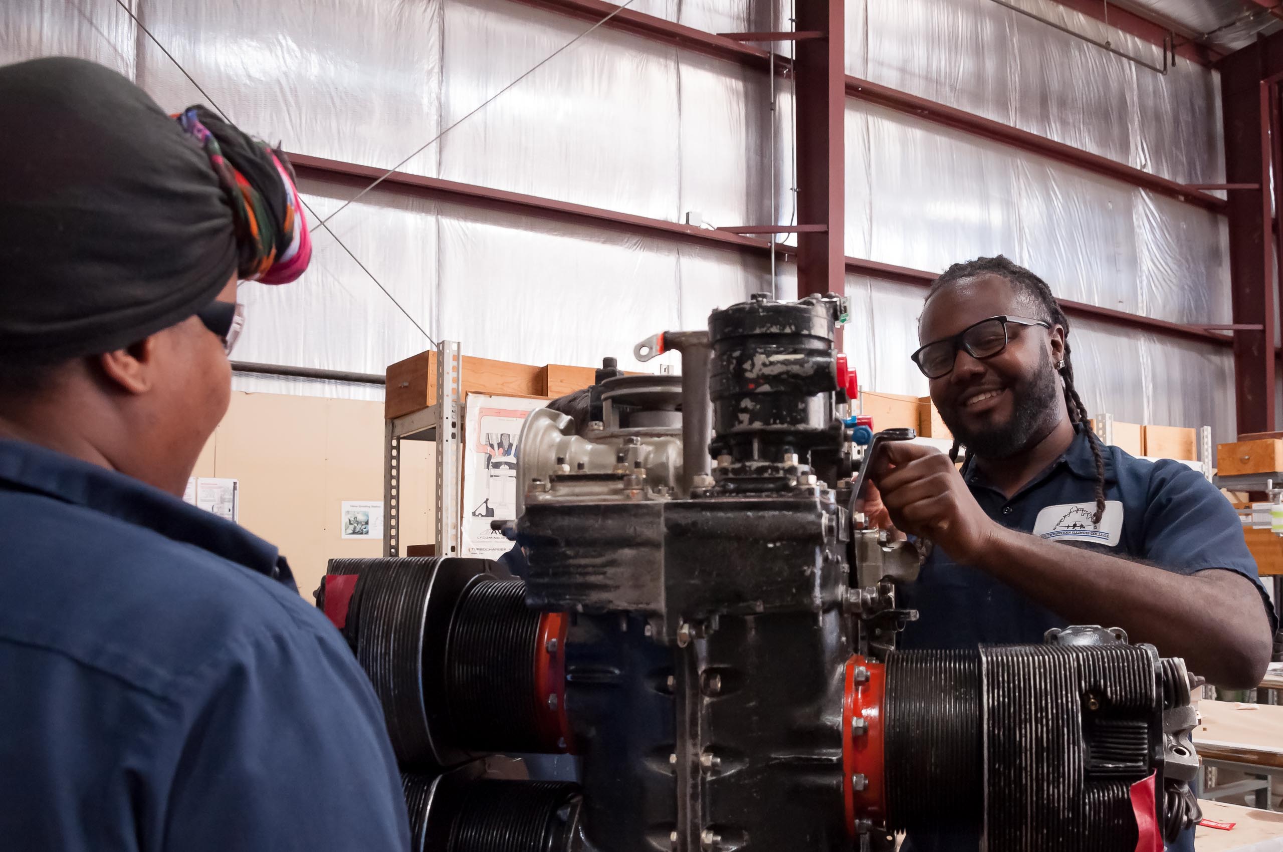 Aircraft Maintenance students working on engine.