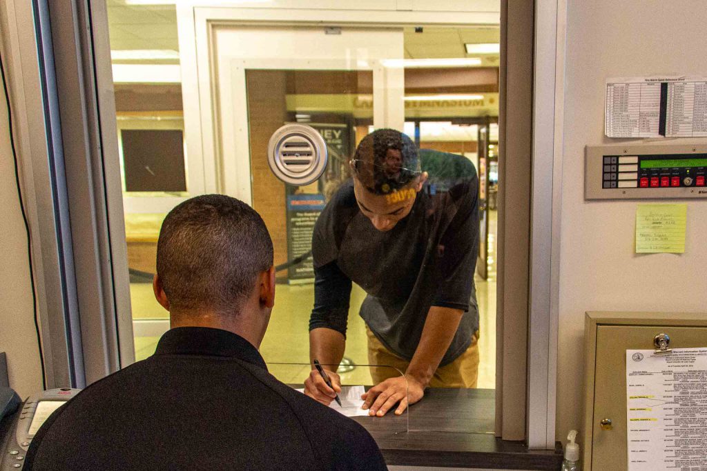 Officer assisting student with paperwork.