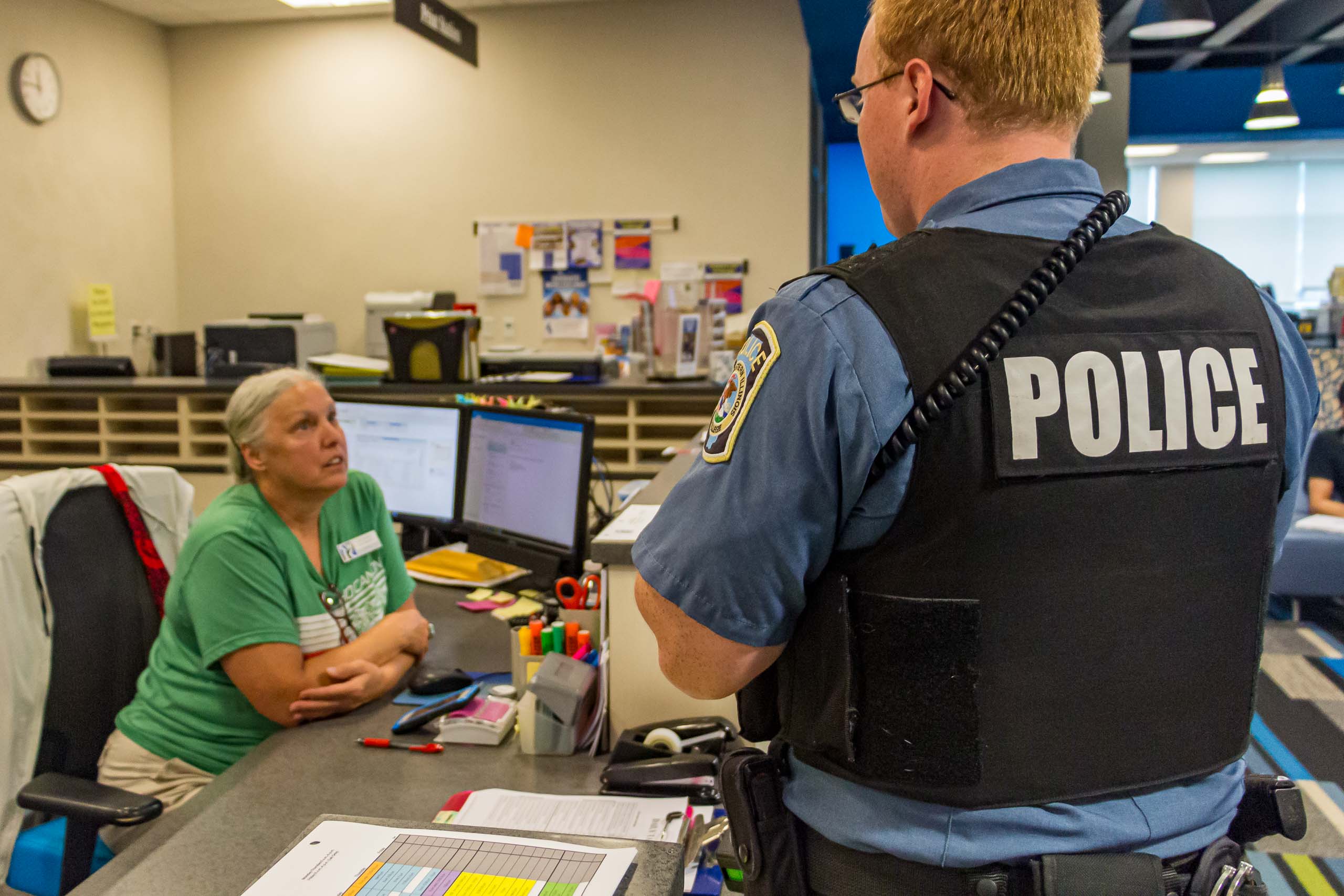 Officer speaking to Welcome Desk attendant in Success Center.