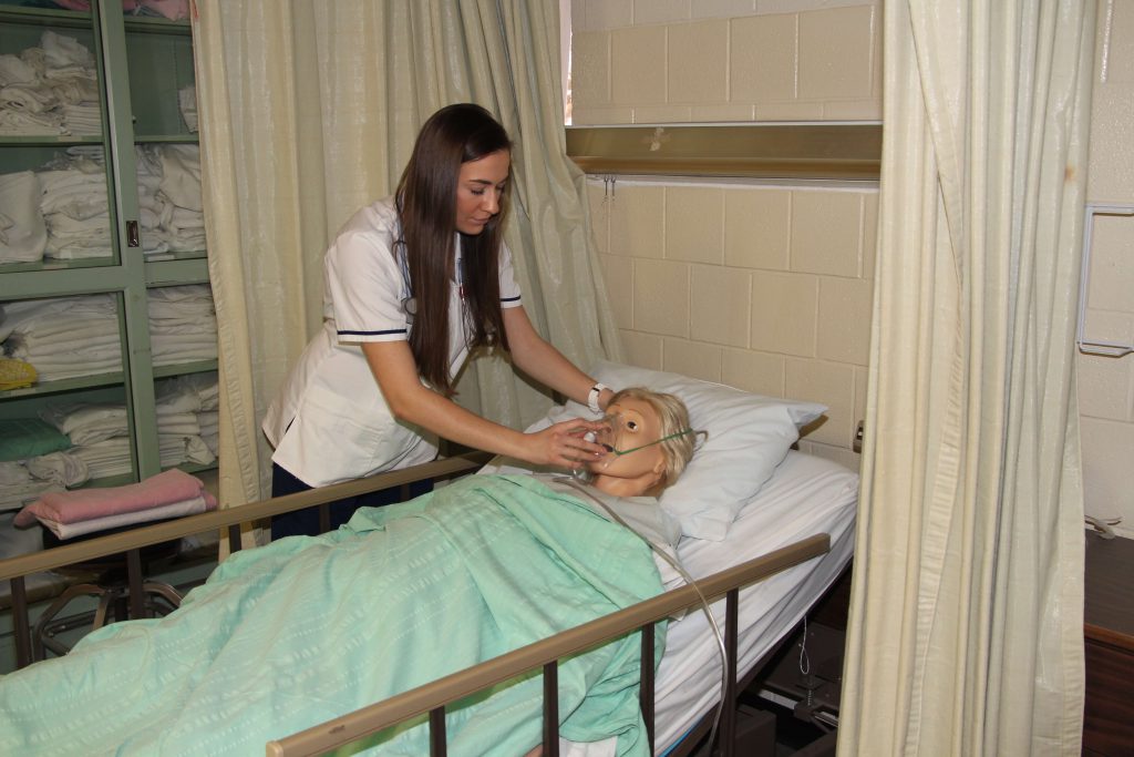 SWIC Nursing Education student testing her skills on a medical mannequin.