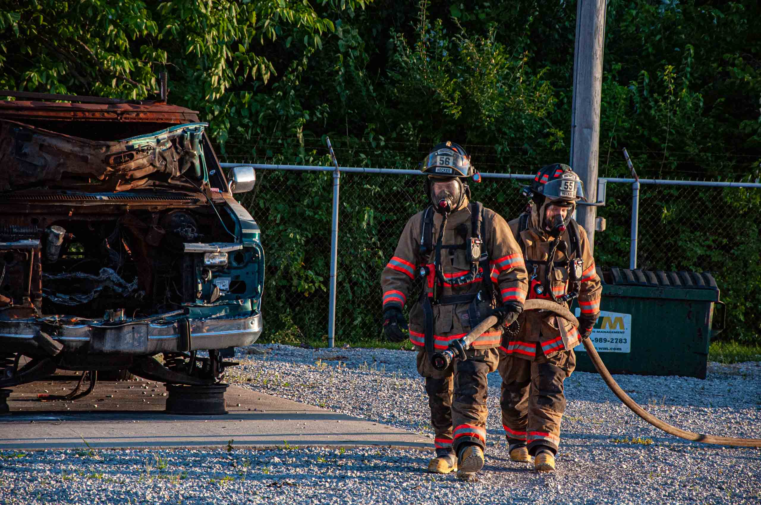 Hecker Fire Science training men in fire gear walking with hose