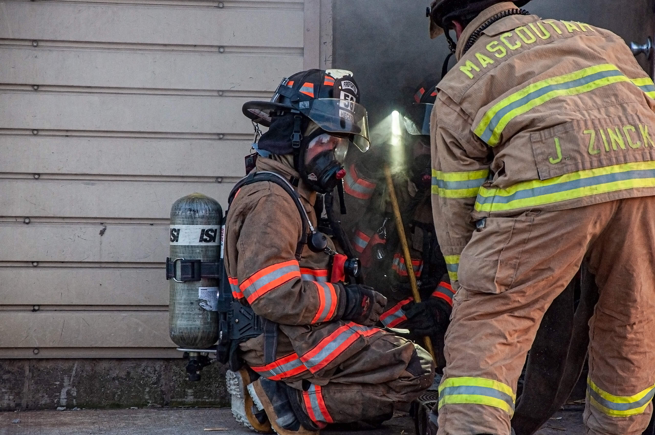 Hecker Fire Science training people in fire gear going into burning building