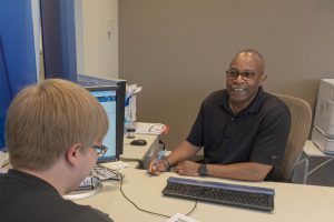 Financial Advisor smiling and helping student in Financial Aid Office