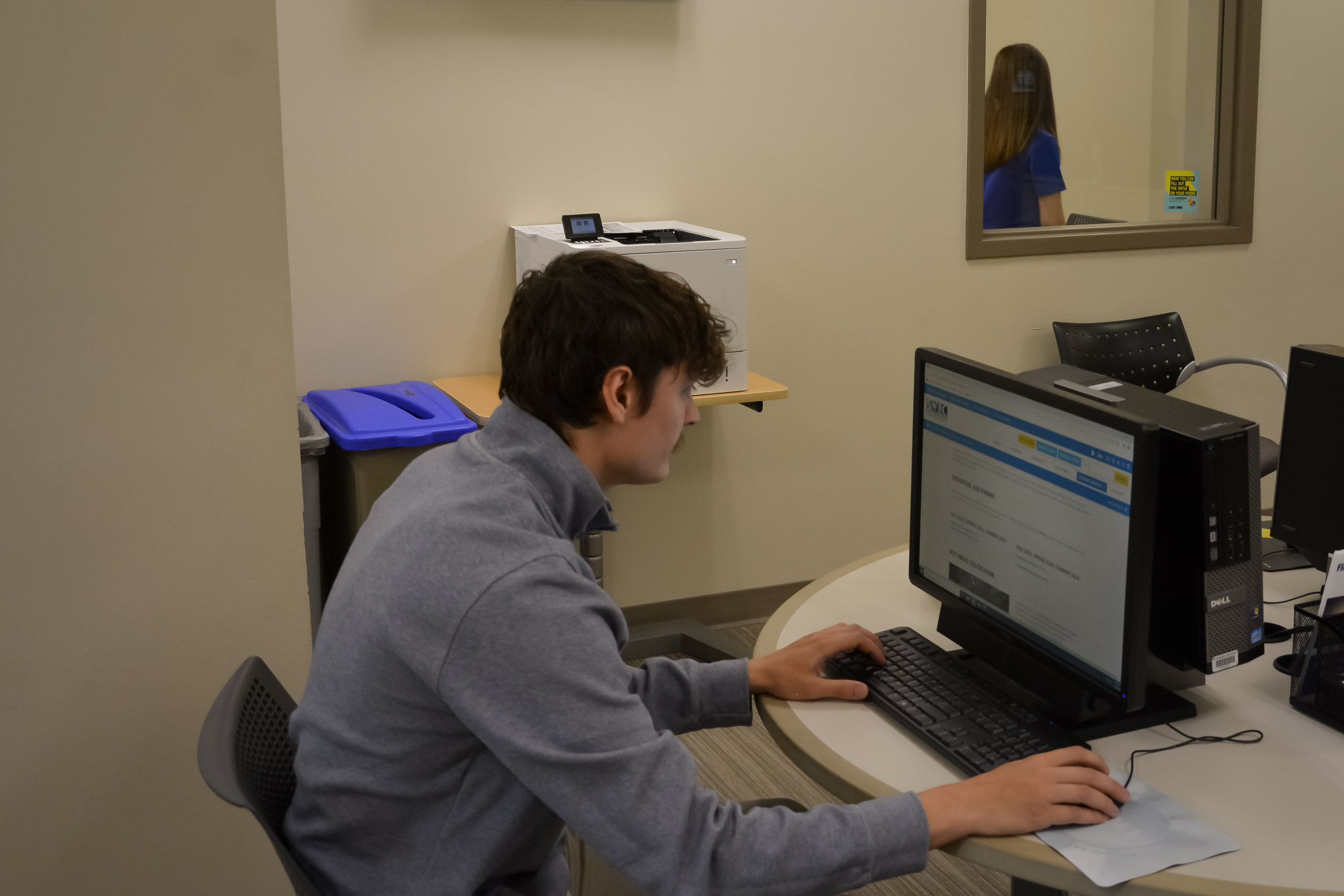 Student at computer station in Financial Aid Office going to IRS to request transcript