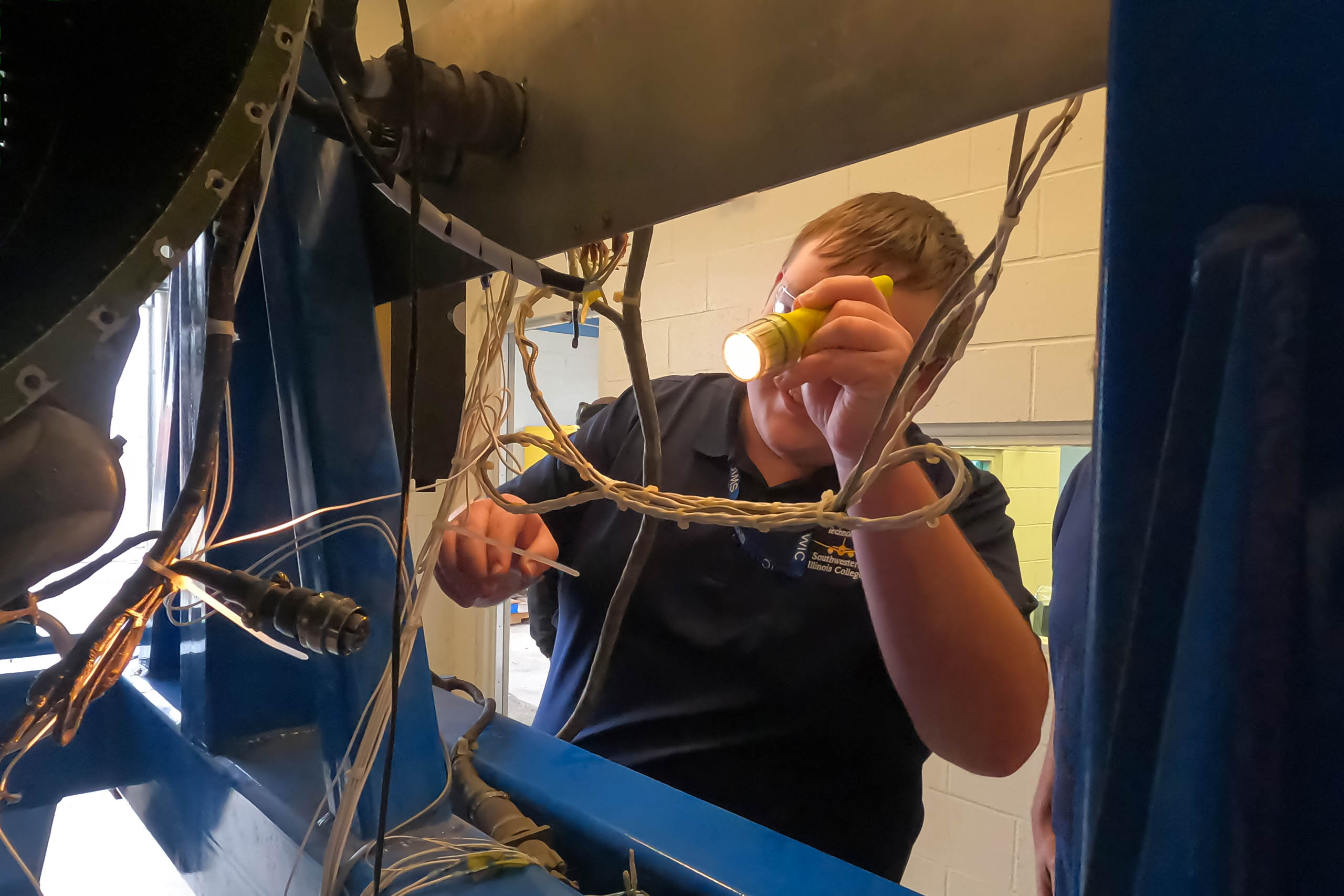 Aviation maintenance student using flashlight