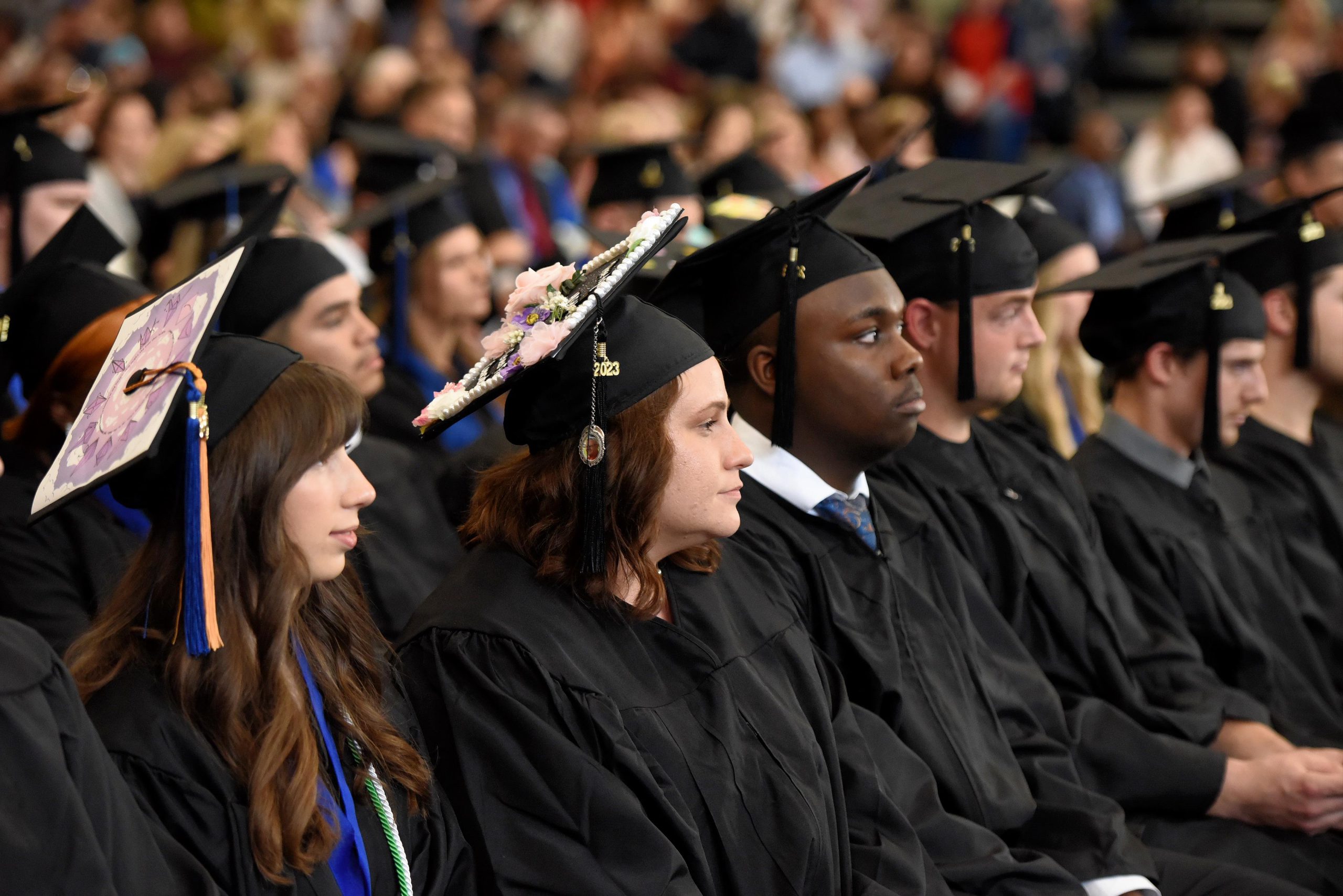 2023 Graduates sit listening during commencement ceremony.